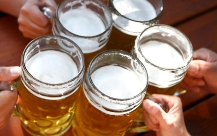 5 friends holding mugs filled with beer to cheers at the Santa Barbara Beer Festival.