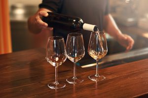 Sommelier fills the glasses during pinot gris wine tasting at a winery on The Urban Wine Trail in Santa Barbara.